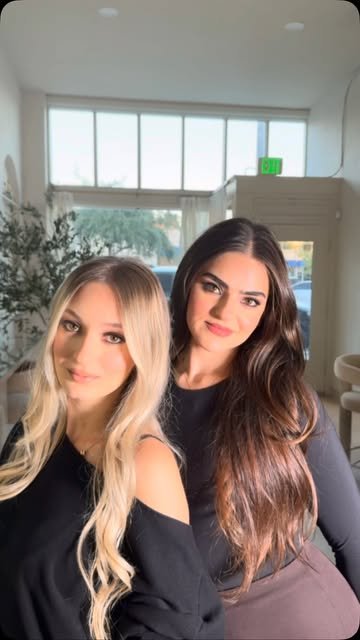 Two clients with long glam waves in the studio